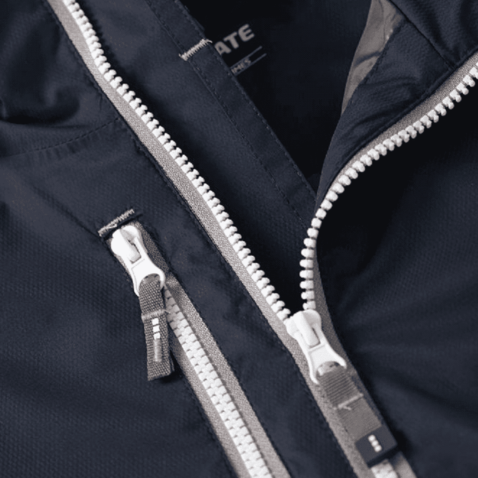A close-up of a navy blue rain jacket featuring contrasting grey zippers and a branded label inside.