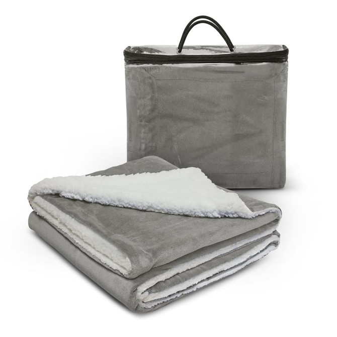A grey luxury blanket with a soft white underside, folded and placed next to a zipped storage bag.
