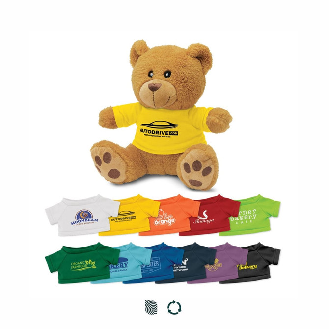 A fluffy brown teddy bear wearing a bright yellow shirt with a logo, surrounded by miniature shirts in various colours.