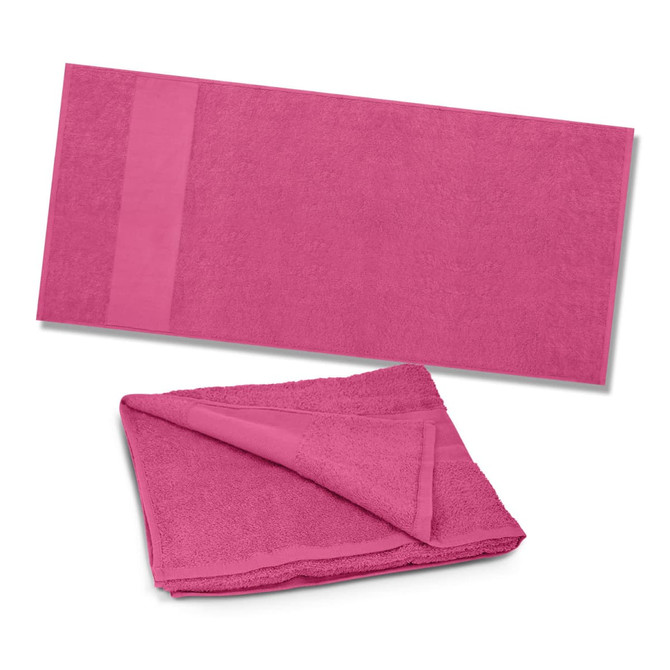 A vibrant pink Dune Beach Towel folded and laid out flat, featuring a soft, plush texture ideal for leisure activities.