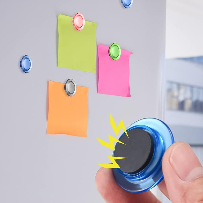 A blue plastic button magnet being placed on a metal surface with colourful sticky notes attached.