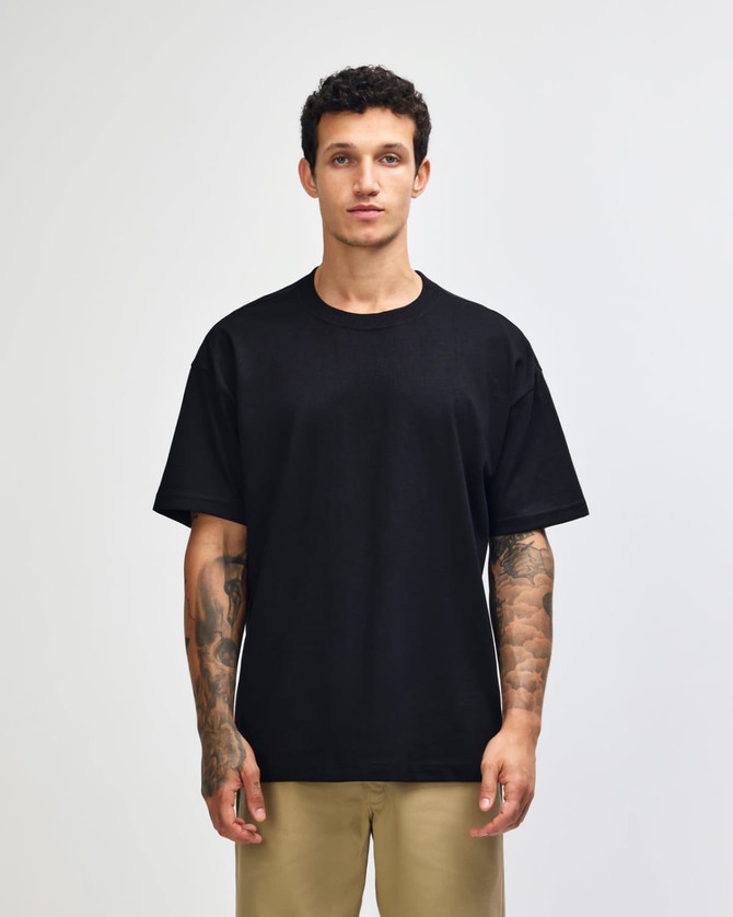 A dark navy heavyweight t-shirt displayed on a model, featuring a simple design and a logo.