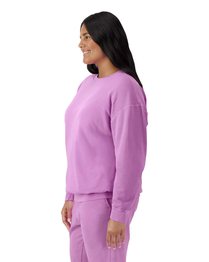 A lightweight crewneck sweatshirt in a vibrant purple, displayed on a model from the side. It features a logo.