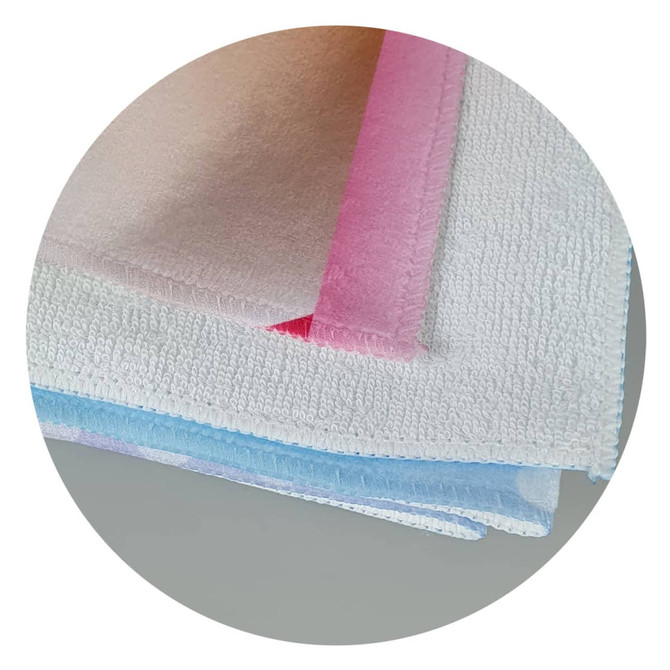 A stack of soft beach towels in pastel colours, featuring a logo on one of the towels.