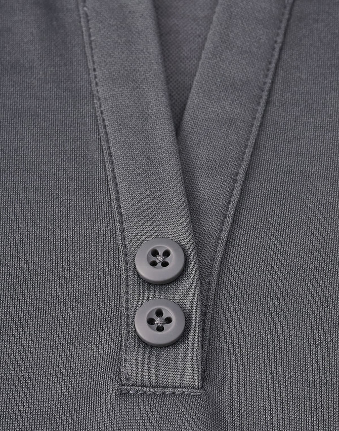 A close-up of a grey polo shirt featuring a placket with two black buttons and a sustainable fabric blend.
