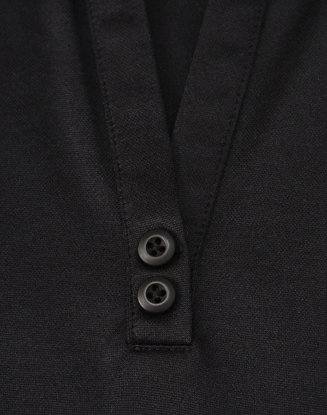 A black women's polo shirt featuring a v-neck and two buttons at the collar, made from sustainable poly/cotton blend.