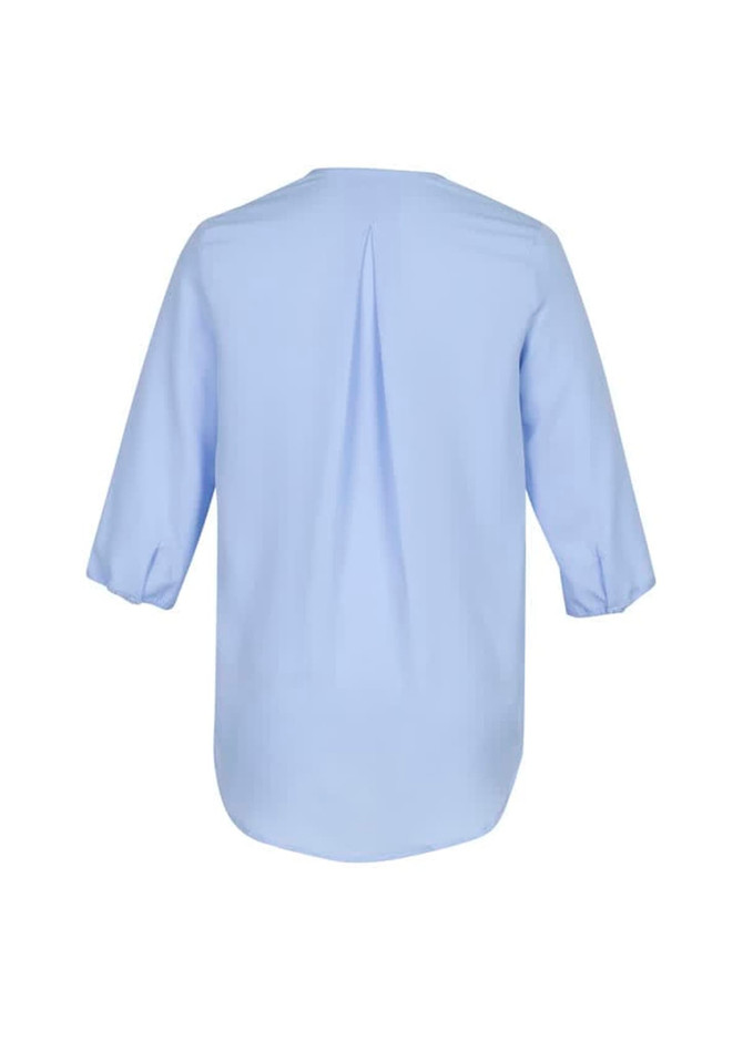 A light blue women's longline blouse featuring a back pleat and three-quarter sleeves. It has a logo visible.