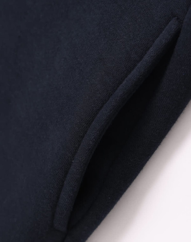 A close-up of a navy fleecy jumper featuring a half-zip collar and pockets. The fabric appears soft and textured.