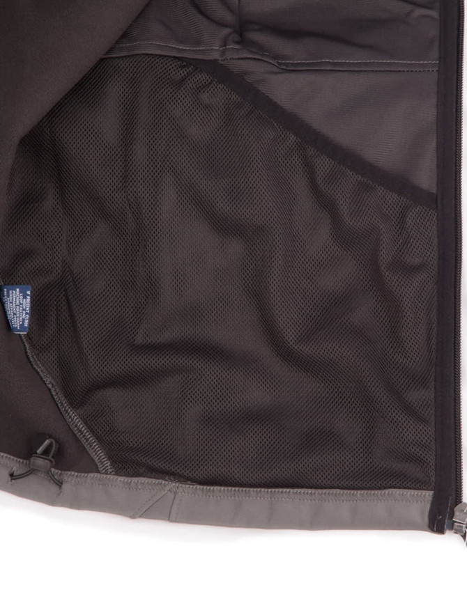 An inside view of a men's softshell high-tech jacket featuring a mesh pocket, predominantly grey in colour.