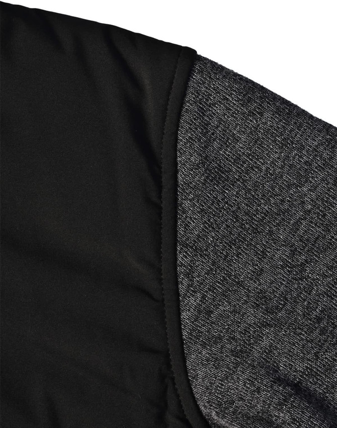 A black quilted jacket featuring a heather grey sleeve. Includes a logo on the fabric.