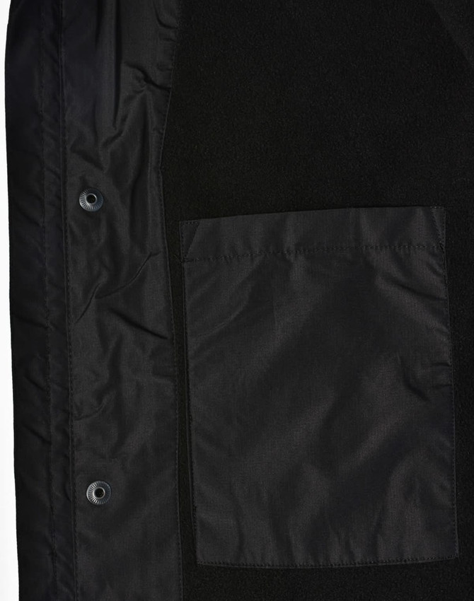 A unisex black jacket featuring a smooth fabric and a patch pocket. It includes snaps for closure and a logo.