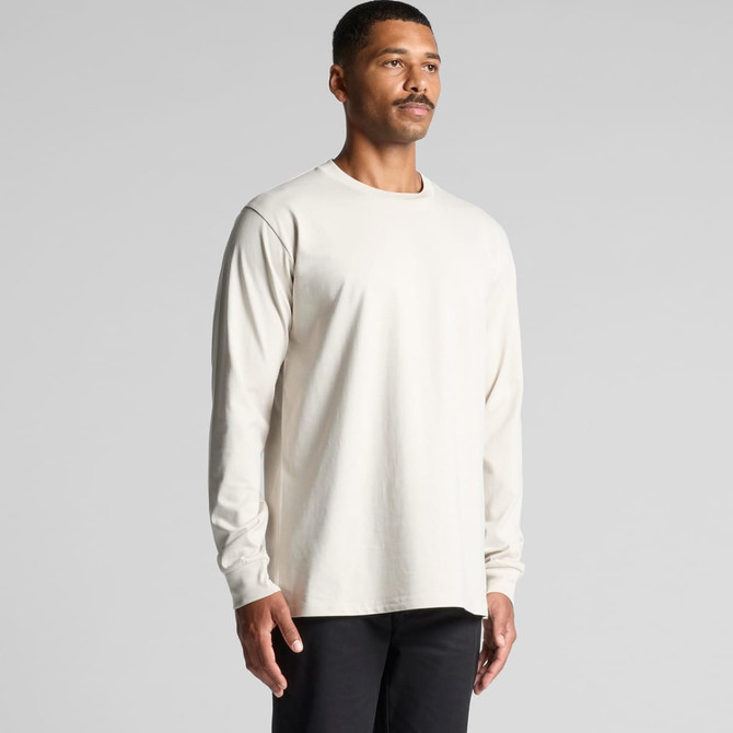 A long-sleeve T-shirt in a light beige colour, featuring a subtle logo, worn by a standing male model.