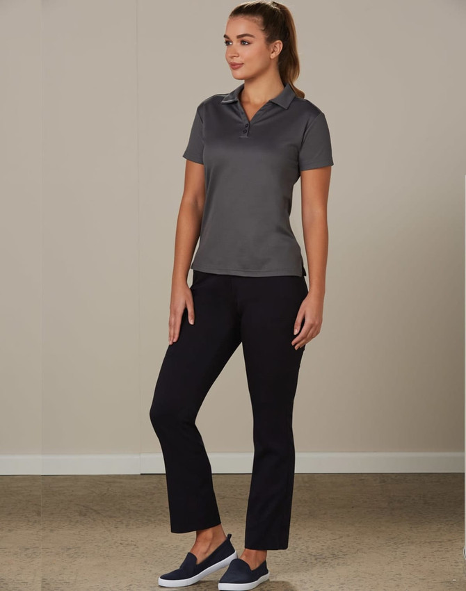 Ladies' utility cargo pants in black, paired with a grey polo shirt, model standing in a neutral setting.
