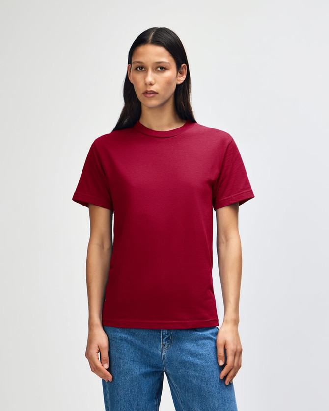 A unisex heavyweight cotton t-shirt in a deep burgundy colour, displayed on a model with straight black hair.