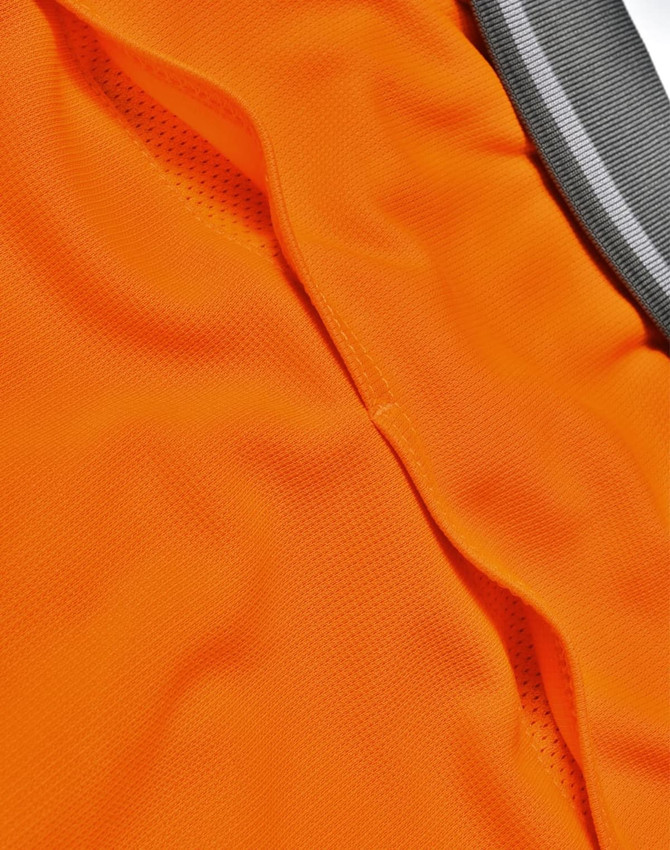 An orange polo shirt featuring a vented design and a grey collar, with a logo present.