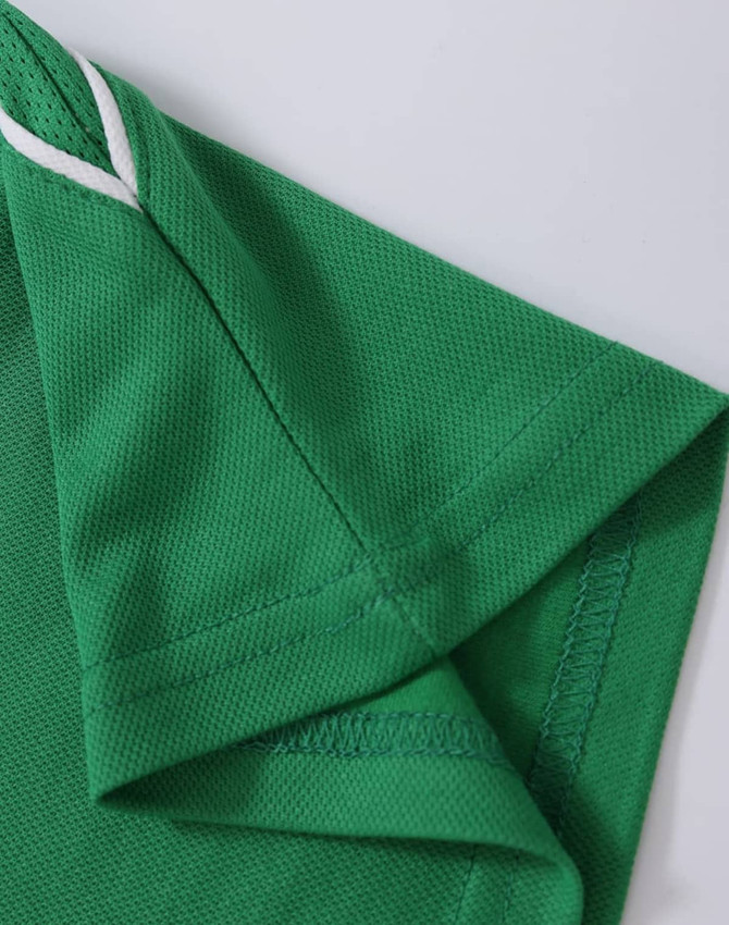 A green polo shirt featuring a detailed collar and sleeve design, with a subtle logo.