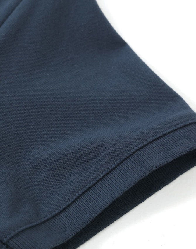 A navy ladies cotton stretch polo shirt featuring a smooth fabric texture and a well-finished hem.