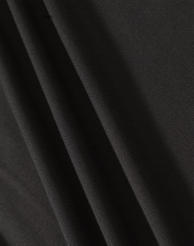 A close-up of black fabric showcasing texture and drape, featuring a subtle weave pattern.