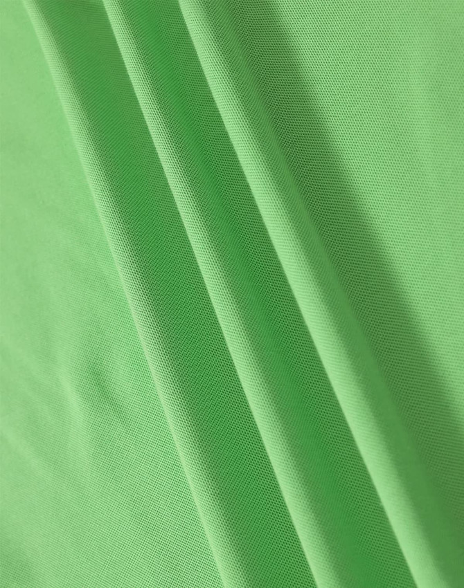 A close-up of soft, textured fabric in vibrant green, showcasing the material of a polo shirt.