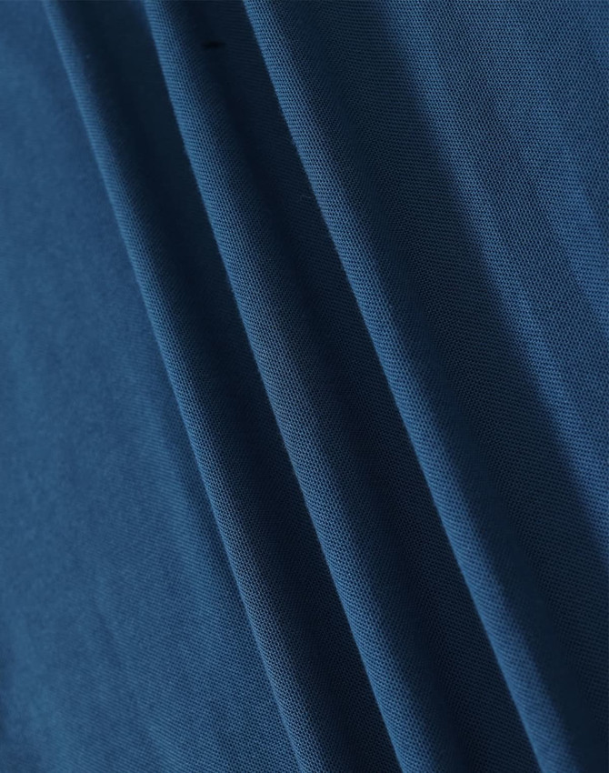 A close-up of blue fabric showcasing the texture and folds of a pique polo shirt. The image features a logo.