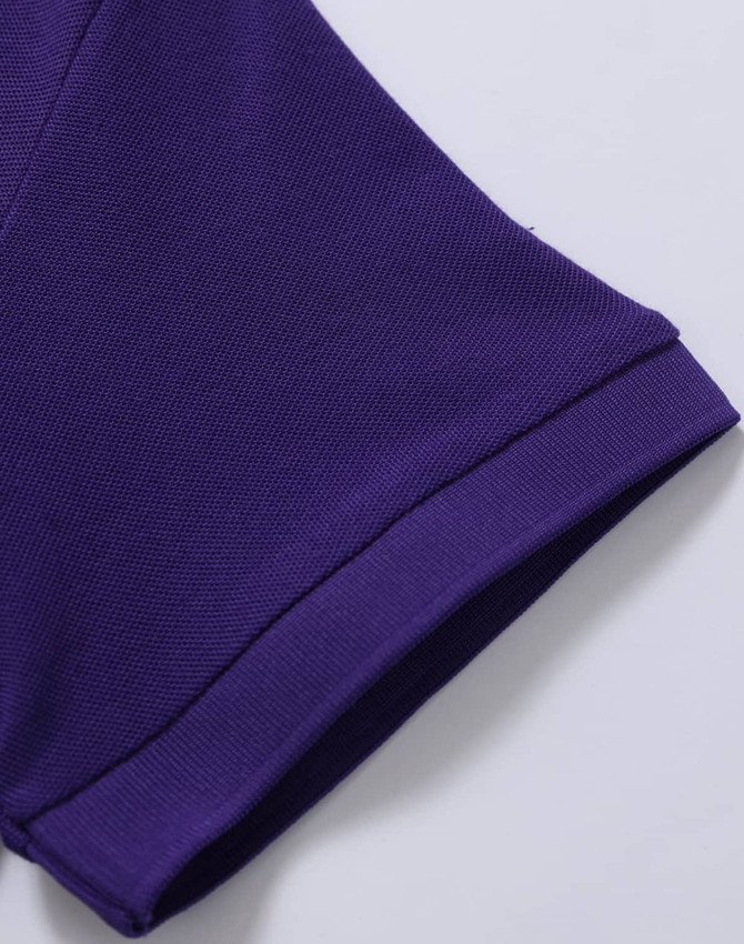 A close-up of a purple polo shirt sleeve, featuring a branded logo and textured fabric.