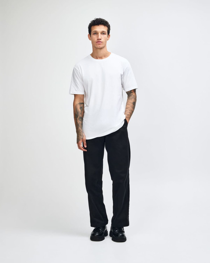 A white unisex short sleeve t-shirt with a fitted design, modelled by a person. Features a branding logo.