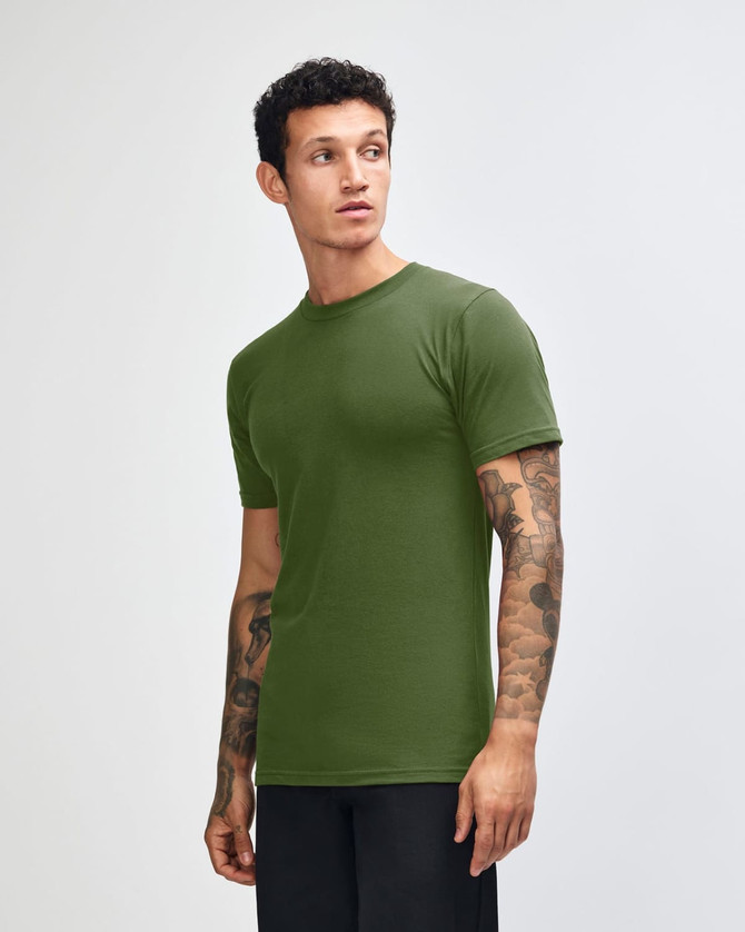 A model wearing an olive green unisex fine jersey short sleeve t-shirt, posed in profile.