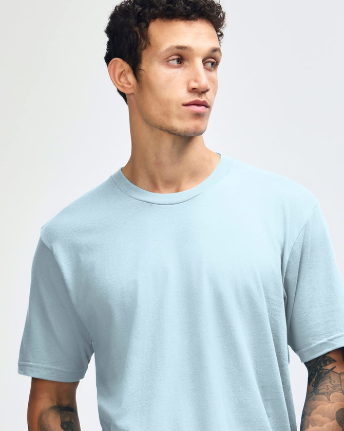 A unisex fine jersey short sleeve t-shirt in light blue, worn by a model with dark jeans and sneakers.
