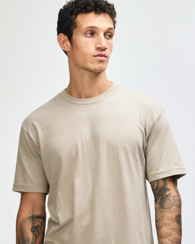 A unisex short sleeve t-shirt in khaki, featuring a relaxed fit and a simple design, with a logo visible.
