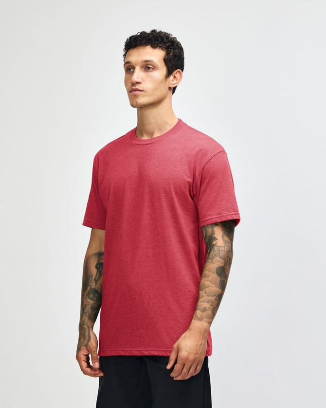 A unisex CVC short sleeve T-shirt in a rich red colour, displayed on a model in profile. It has a logo.
