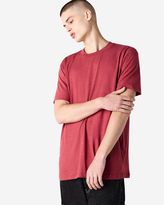 A unisex short sleeve T-shirt in a warm red colour, displayed on a model with a simple design and logo.