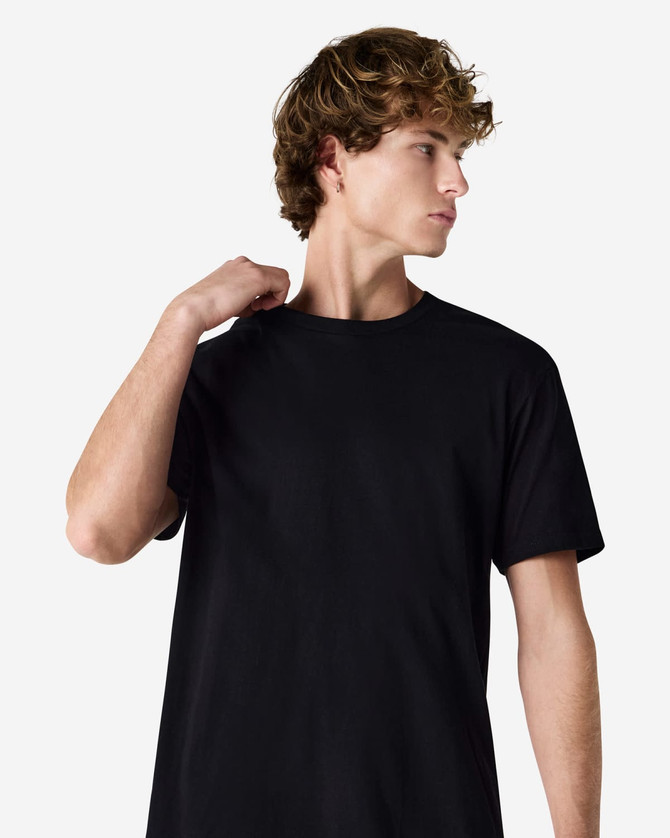 A black unisex short sleeve T-shirt worn by a model, showcasing a simple, classic design.