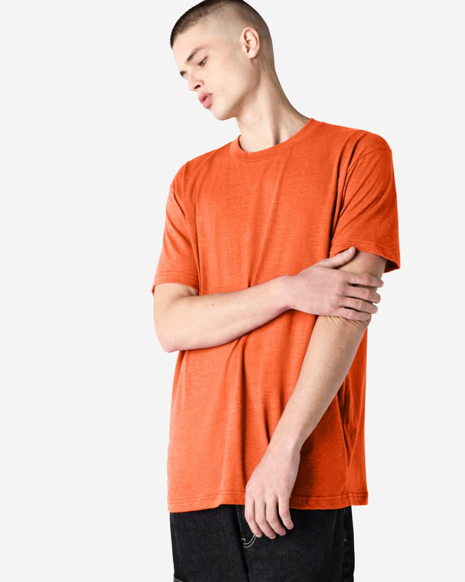 An orange unisex short sleeve T-shirt is displayed on a model with a neutral background. The shirt has a simple design and consists of soft fabric.