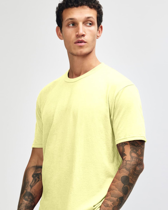 A model wearing a bright yellow unisex short sleeve t-shirt with a simple design and no visible logos.