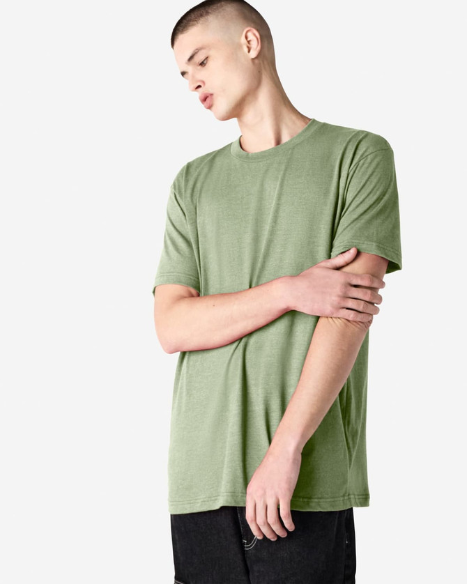 A green unisex CVC short sleeve T-shirt is displayed on a model with a neutral background. It features a logo.