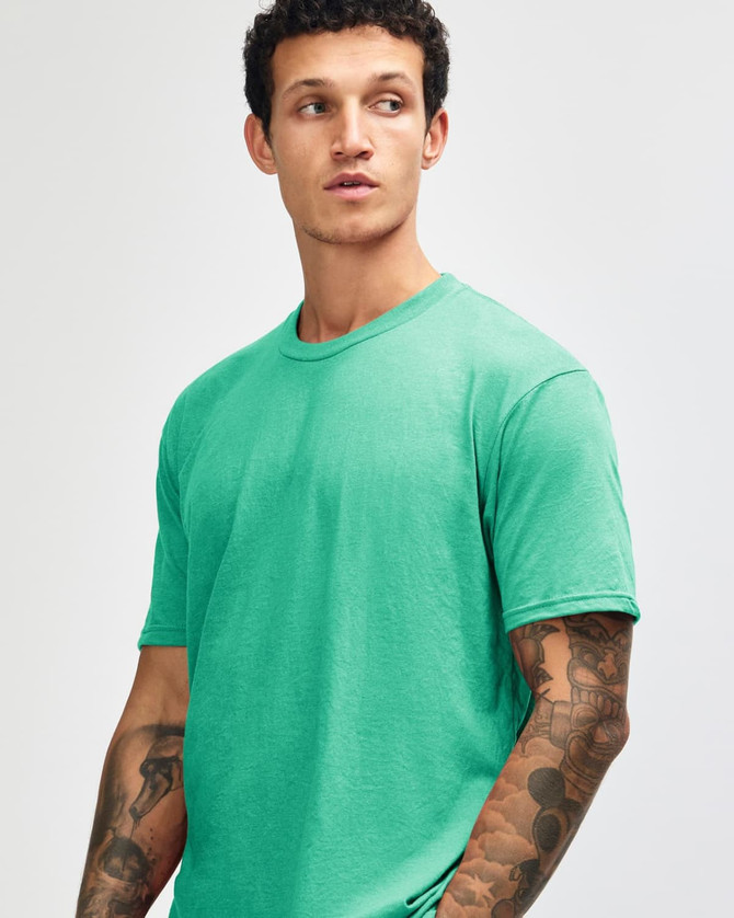 A model wearing a unisex short sleeve T-shirt in vibrant mint green, featuring a logo on the sleeve.