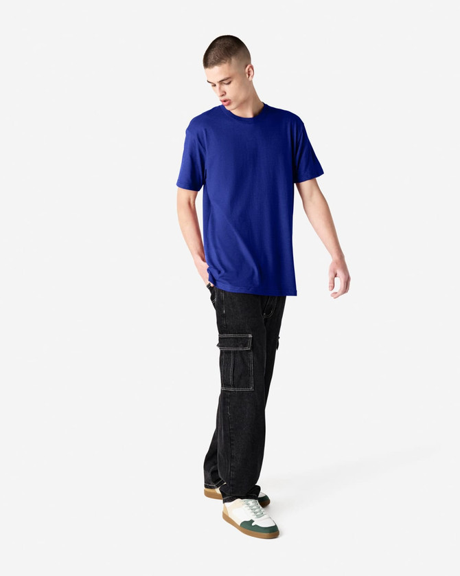 A unisex short sleeve t-shirt in blue, paired with black cargo pants, displayed on a model.