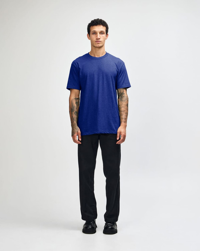 A unisex short sleeve t-shirt in blue, paired with black cargo pants, displayed on a model.