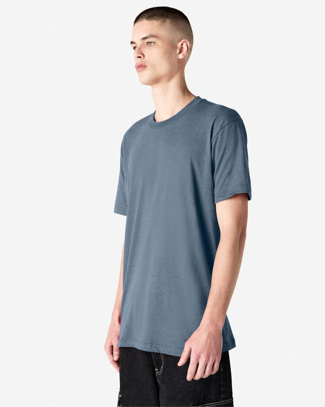 A unisex short sleeve t-shirt in a blue colour, featuring a logo on the front. The model stands against a light background.