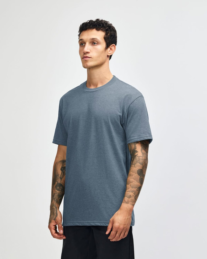 A unisex short sleeve t-shirt in a blue colour, featuring a logo on the front. The model stands against a light background.