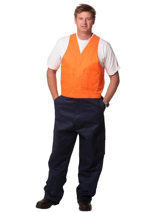A man wearing a two-tone orange and navy cotton drill overall with a v-neck design and pockets.