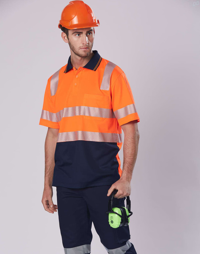 An orange and navy safety polo shirt with reflective strips, worn with a hard hat and holding ear protection.
