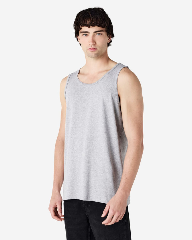 A grey Gildan Heavy Cotton adult tank top displayed on a model, featuring a plain design and a logo.