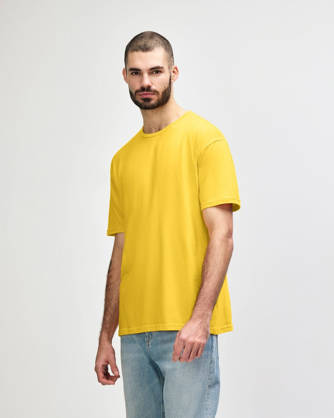 A yellow Gildan Softstyle adult T-shirt displayed on a model standing sideways. The shirt has a logo.