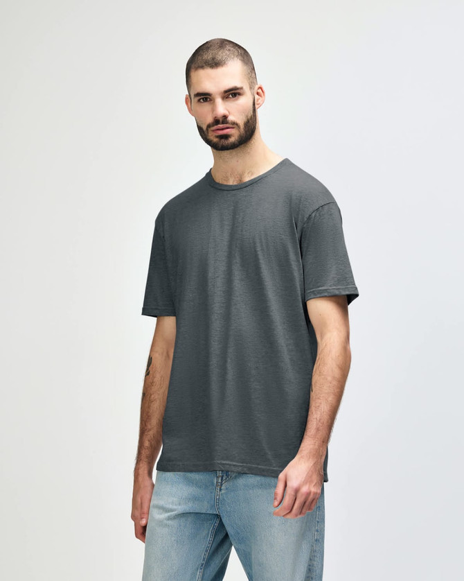 A grey Gildan Softstyle adult T-shirt displayed on a model, featuring a simple design and a relaxed fit.