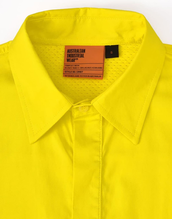 A bright yellow long-sleeve work shirt with perforated tape and a collar. The shirt features a tag and branding.