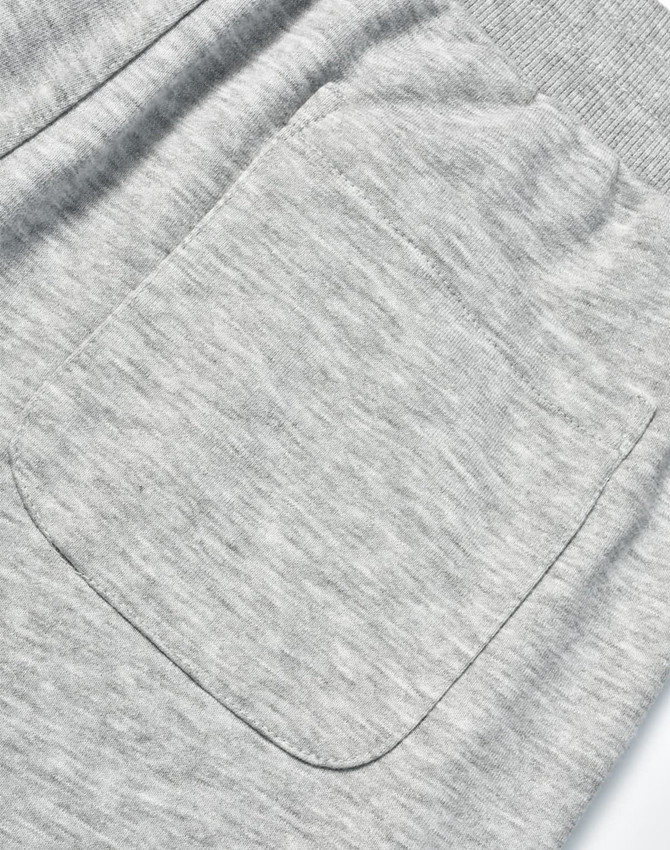 A close-up of grey poly/cotton terry sweat pants featuring a single back pocket and elastic waistband.
