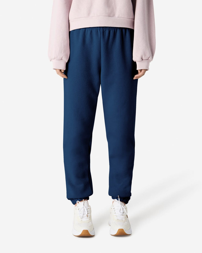 Unisex sweatpants in navy blue, featuring an elastic waistband and cuffs, paired with a light pink top and white shoes.