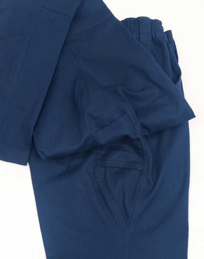 Navy unisex cotton stretch ripstop segmented work pants with an elastic waistband and side pockets. Features a logo.
