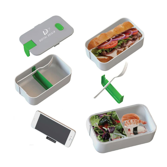 A grey lunch box with a green divider, containing sandwiches and salad, alongside a fork and phone holder.